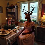 advent_wreath amber_eyes anthro antlers big_breasts black_ear_tips black_fingernails black_lips black_nose book bookshelf bread breasts brown_body brown_fur candle chair christmas_ornament christmas_theme cleavage clothed clothed_anthro clothed_female clothing conifer curtains curtains_open detailed_background dirndl dress eyebrows female food fully_clothed fur furniture horn houseplant inner_ear_fluff inside lamp lips looking_at_viewer on_chair open_mouth open_smile ornaments photorealism picture_frame pink_clothing pink_dress plant plate radiator realistic realistic_fur rug sitting sitting_on_chair smile snow snowing solo table tree tuft vintage wall_(structure) window winter winter_background silvicultor cervid mammal hi_res portrait three-quarter_portrait